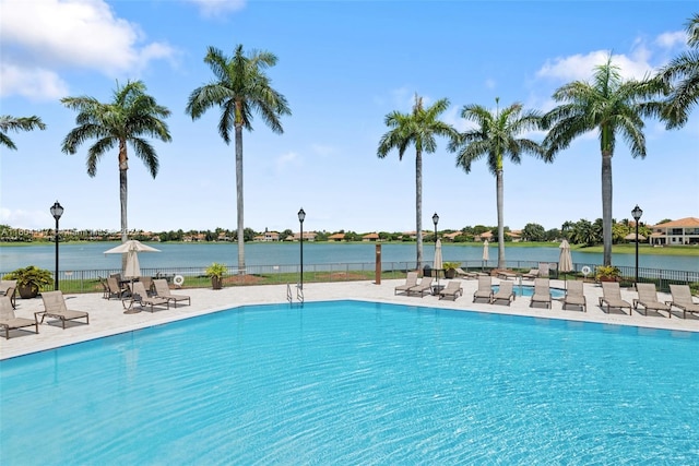 view of pool featuring a water view and a patio