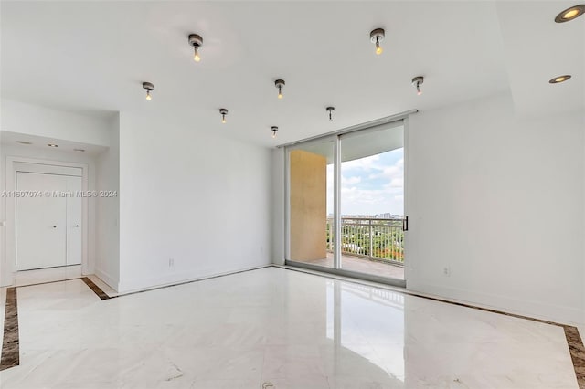 unfurnished room featuring a wall of windows