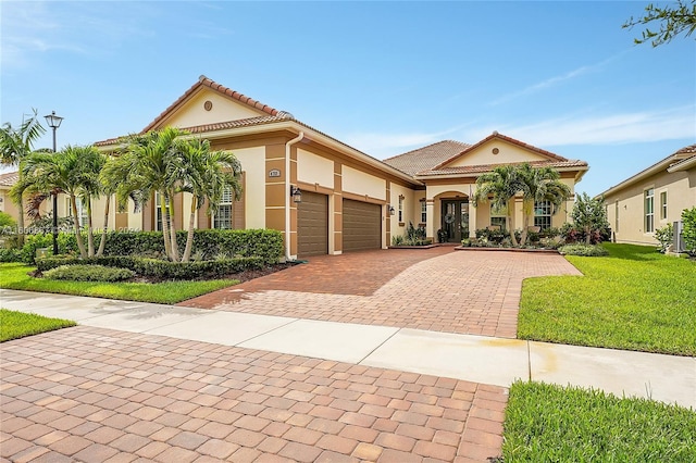 mediterranean / spanish-style house featuring a garage and a front yard