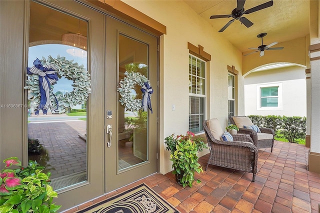 entrance to property featuring a patio area, french doors, and ceiling fan