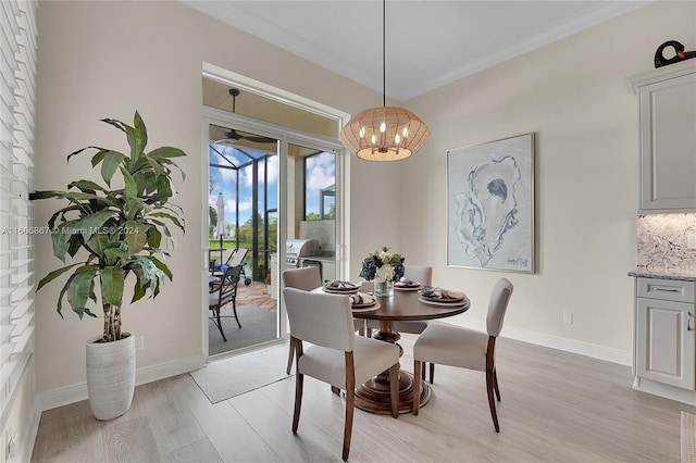 dining area featuring crown molding, a chandelier, and light wood-type flooring