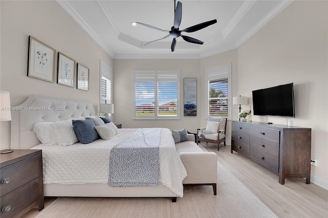 bedroom with ornamental molding, a raised ceiling, ceiling fan, and light wood-type flooring