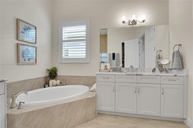 bathroom with tiled tub and vanity