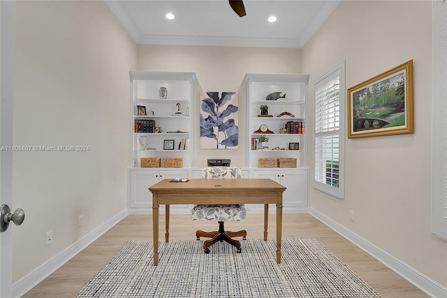 office space featuring ornamental molding, light wood-type flooring, and built in shelves