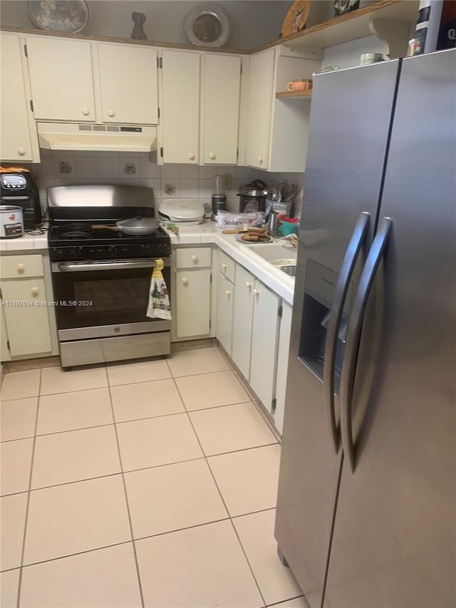 kitchen with white cabinetry, light tile patterned flooring, and appliances with stainless steel finishes