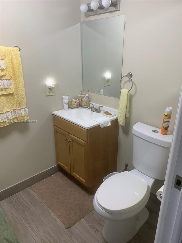 bathroom featuring hardwood / wood-style flooring, vanity, and toilet