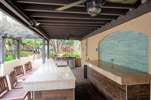 view of patio / terrace with a grill, ceiling fan, and an outdoor kitchen