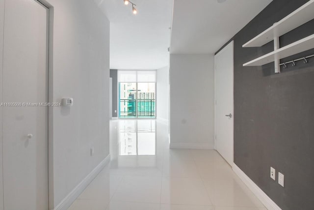 tiled spare room featuring track lighting