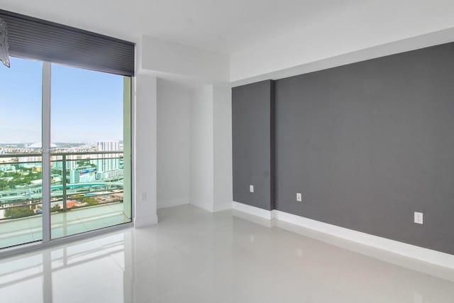 unfurnished room featuring baseboards and a city view