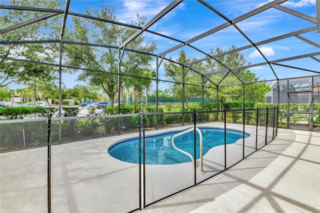 view of swimming pool featuring a lanai and a patio area