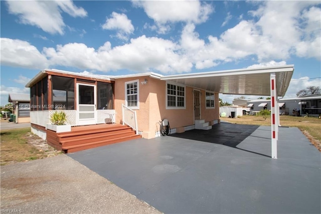 manufactured / mobile home with a carport, aphalt driveway, crawl space, and a sunroom