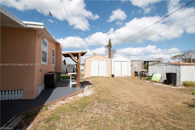 view of yard featuring a storage unit, a patio area, and an outdoor structure