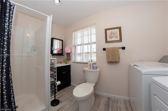 full bath featuring a stall shower, independent washer and dryer, vanity, and toilet