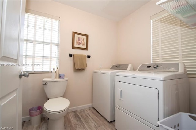 laundry room with laundry area, independent washer and dryer, light wood-style flooring, and baseboards