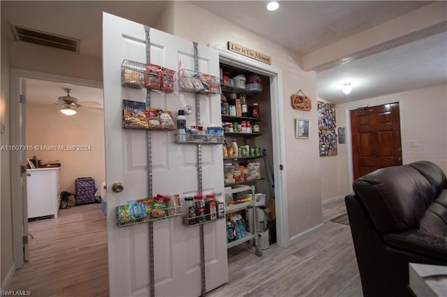 interior space with a ceiling fan, baseboards, visible vents, and wood finished floors