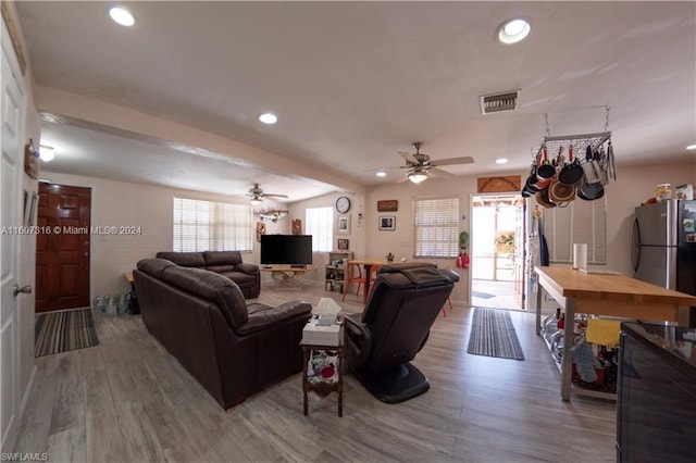 living room with a ceiling fan, visible vents, wood finished floors, and recessed lighting