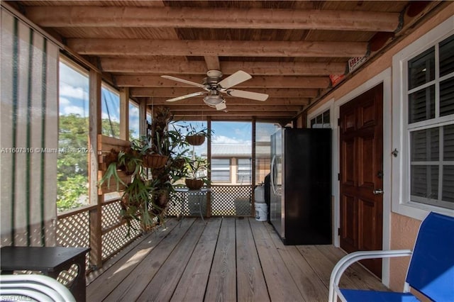 unfurnished sunroom with ceiling fan and beamed ceiling