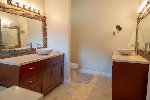 bathroom with double vanity, tile flooring, and toilet