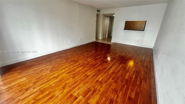 spare room featuring wood-type flooring