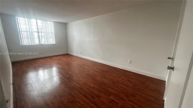 spare room featuring dark wood-type flooring