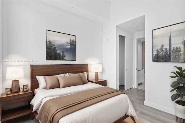 bedroom featuring ensuite bath and hardwood / wood-style floors