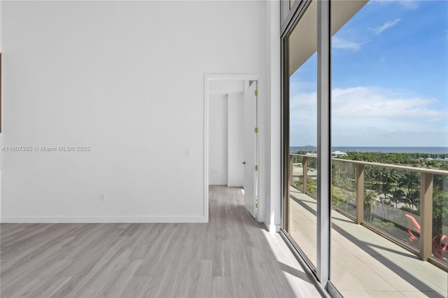 empty room with a water view and light hardwood / wood-style floors