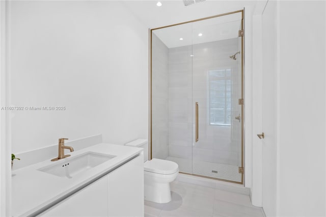 bathroom featuring tile patterned floors, vanity, toilet, and a shower with shower door