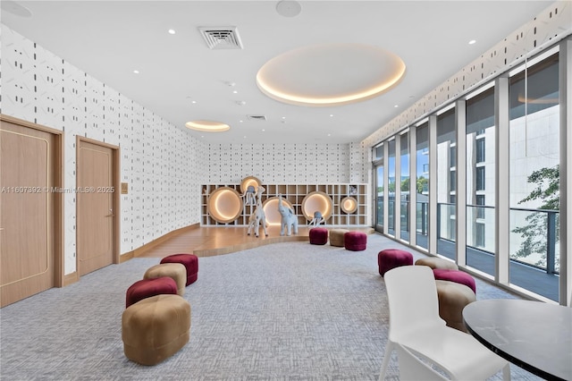 rec room featuring carpet flooring and a tray ceiling