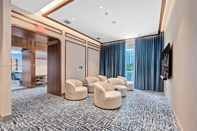 home theater room featuring ornamental molding and carpet