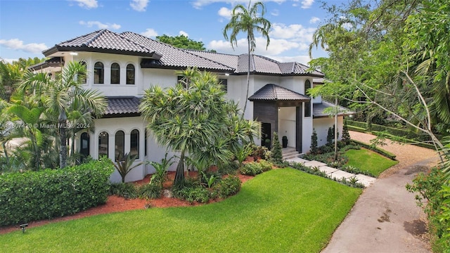 mediterranean / spanish home with a front lawn