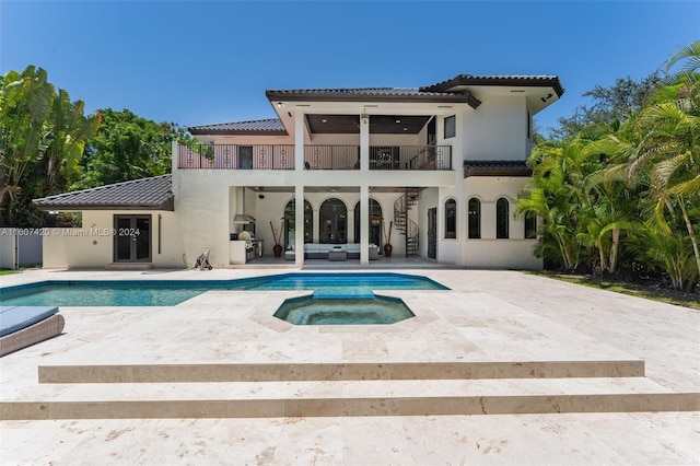 back of house with a patio area, a balcony, an outdoor hangout area, and a pool with hot tub