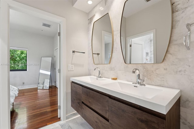 bathroom featuring vanity, hardwood / wood-style flooring, and tile walls