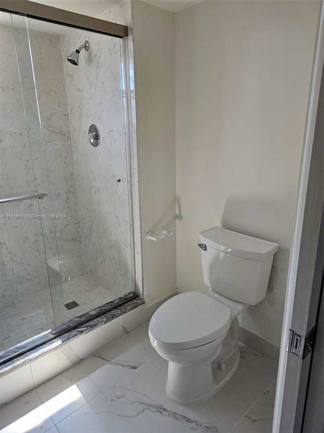 bathroom with tile flooring, a shower with shower door, and toilet