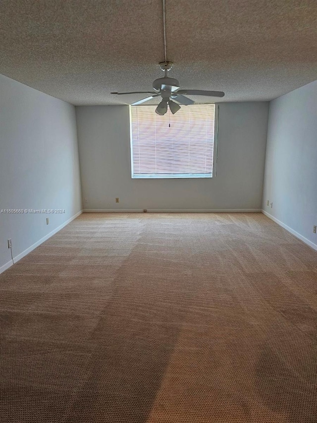 spare room featuring carpet flooring, ceiling fan, a textured ceiling, and baseboards