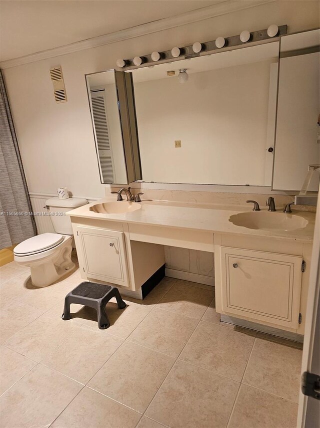 bathroom featuring dual bowl vanity, tile flooring, crown molding, and toilet