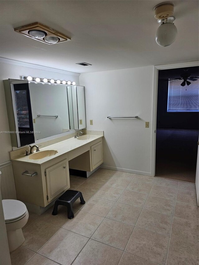 bathroom featuring tile flooring, toilet, and double vanity