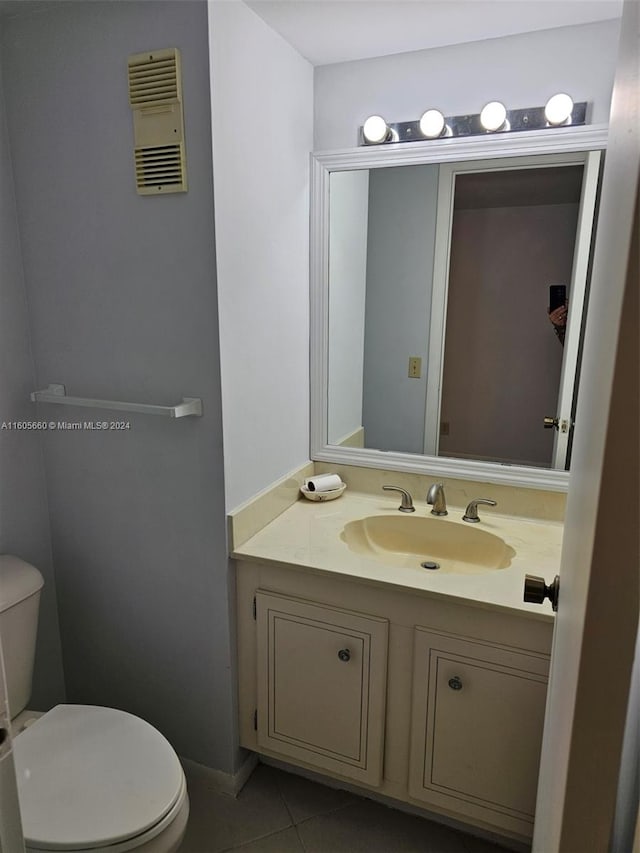 bathroom featuring vanity, toilet, and tile floors