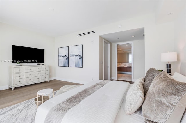 bedroom featuring wood-type flooring and connected bathroom