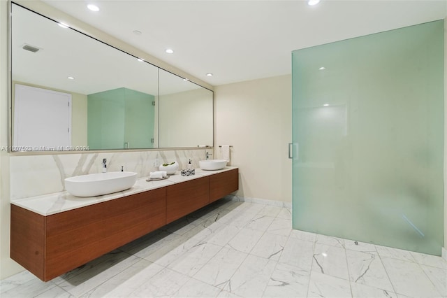 bathroom featuring tasteful backsplash, double sink vanity, tile walls, and tile patterned flooring