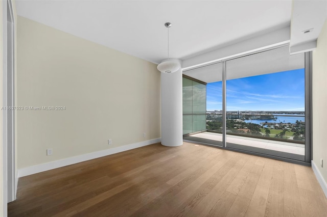 spare room with wood-type flooring and a water view