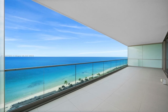 balcony featuring a water view and a view of the beach