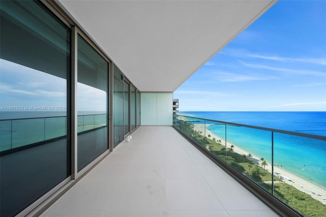 balcony featuring a water view and a view of the beach