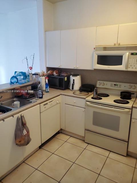 kitchen featuring white cabinetry, white appliances, and light tile patterned floors