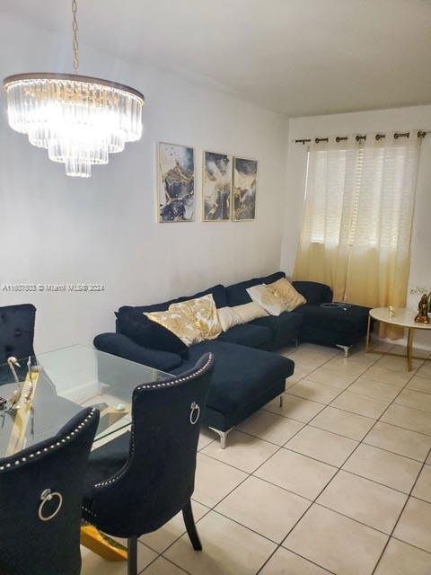 living room featuring light tile patterned flooring and a chandelier