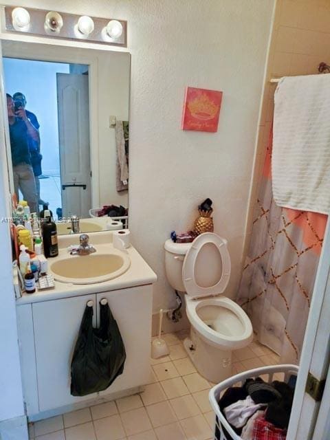 bathroom with tile patterned floors, a shower with curtain, vanity, and toilet