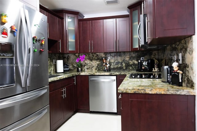 kitchen featuring stainless steel appliances, light stone counters, tasteful backsplash, and light tile flooring
