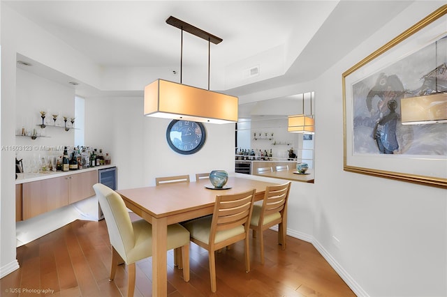 dining room with bar and dark hardwood / wood-style floors