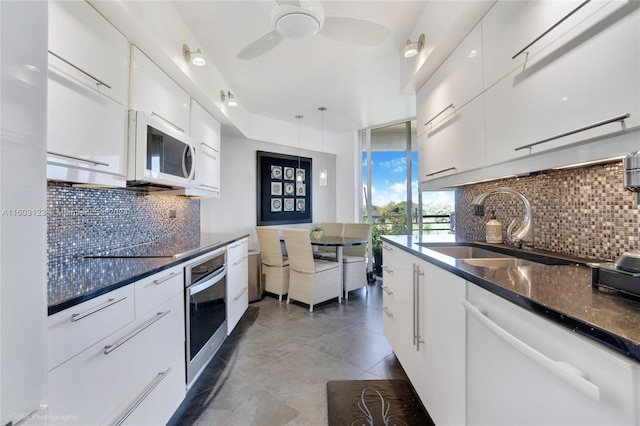 kitchen featuring sink, white cabinets, white appliances, and tasteful backsplash