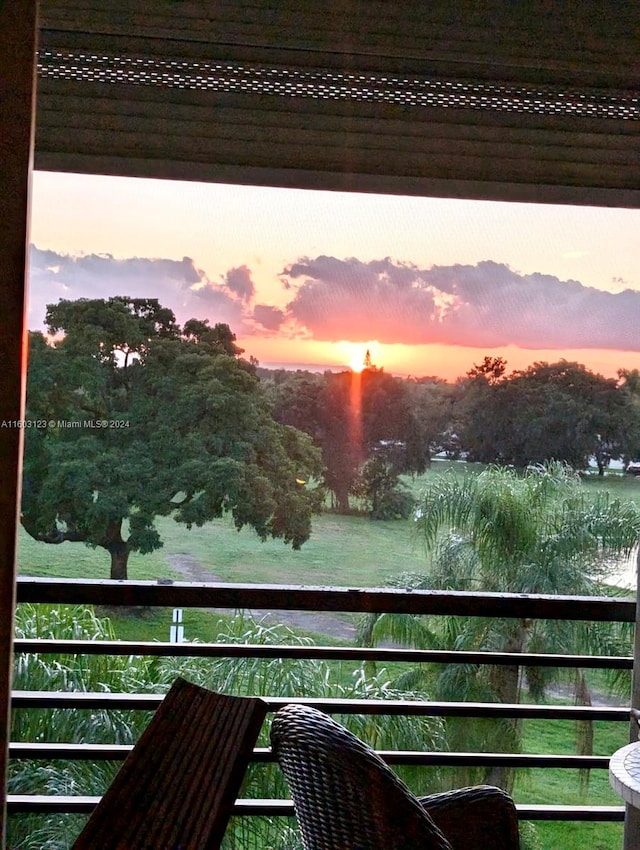 balcony at dusk featuring a water view