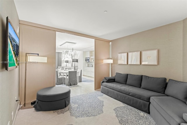 living room featuring light carpet and an inviting chandelier